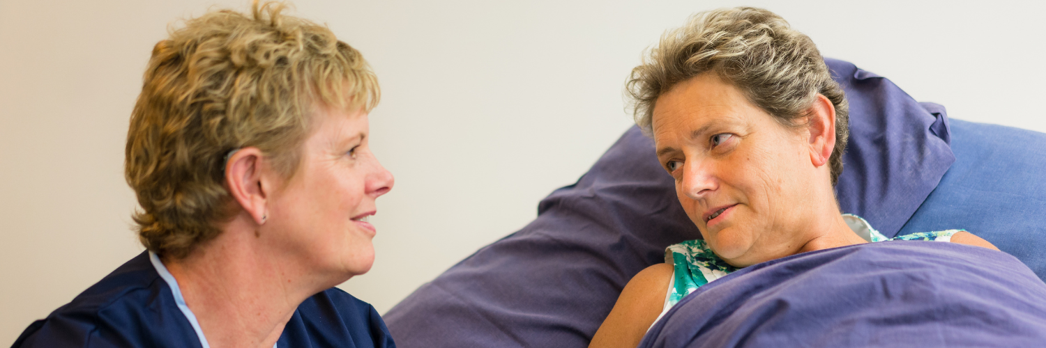 A nurse and a patient speaking to one another