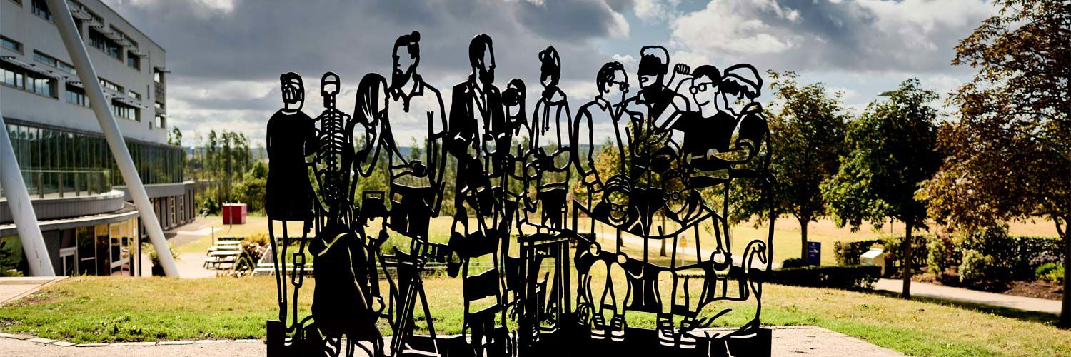A steel sculpture of linocut-style cutouts of different individuals.