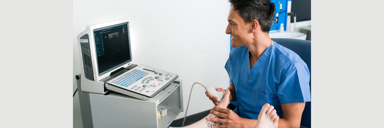 A technician using an ultrasound device on a patient's foot.