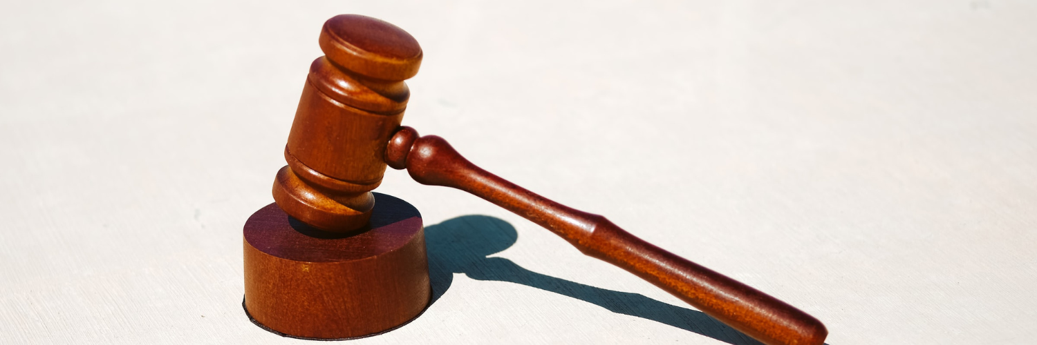 An image of a gavel and block, as used in the legal system.