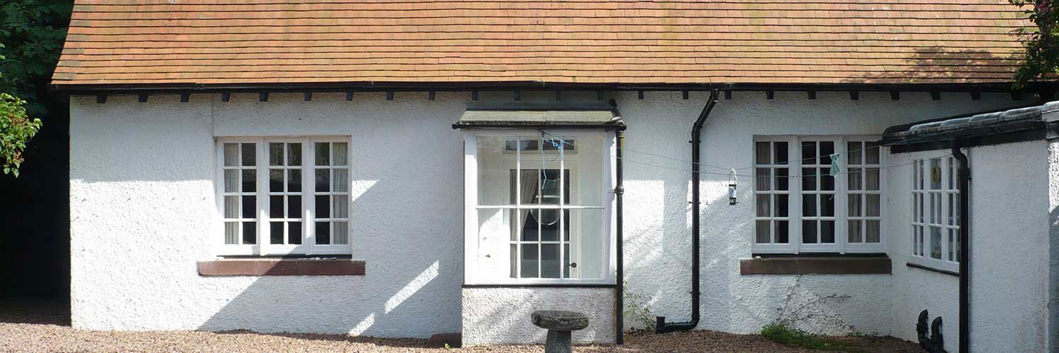 Madras Lodge, a one-story building painted white with a copper-toned roof.