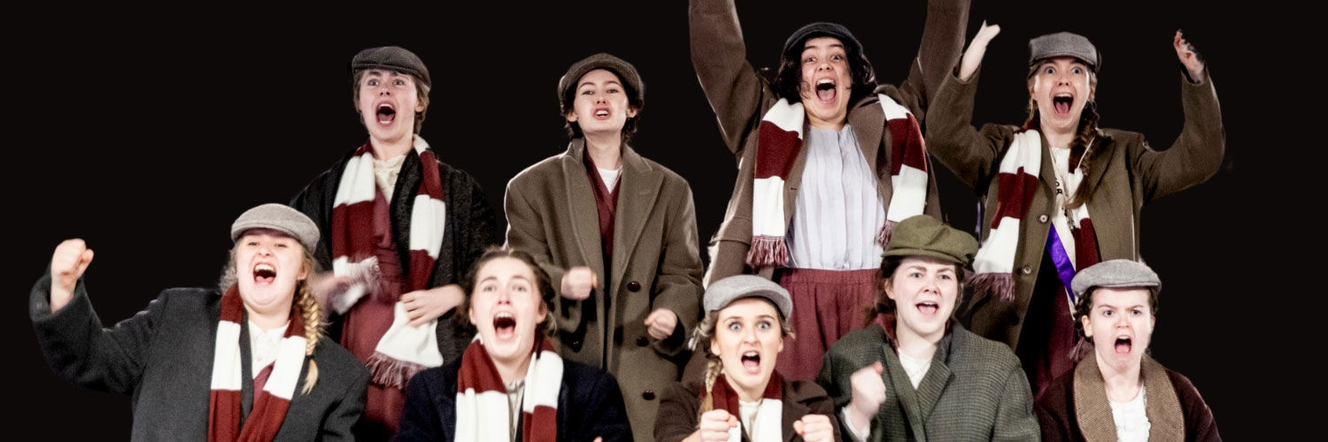 A group of students in costume, performing at the acting showcase.