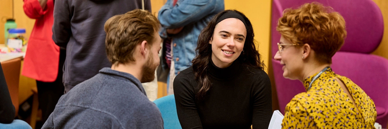 Two prospective students speaking with a lecturer at an Open Day event.