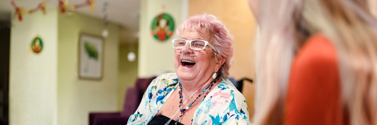 Elderly woman in care home talking to staff