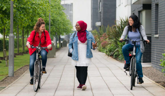 Friends cycling on QMU campus grounds