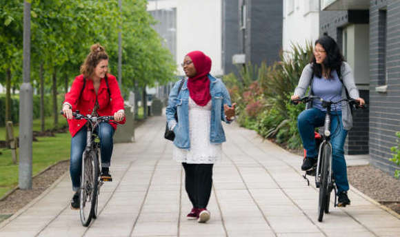 Friends cycling on QMU campus grounds