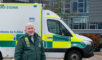 Paramedic standing in front of an ambulance