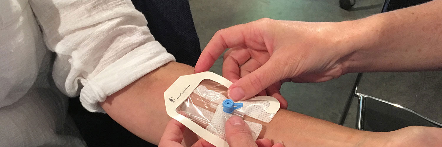 A student nurse fitting a cannula to a patient's arm
