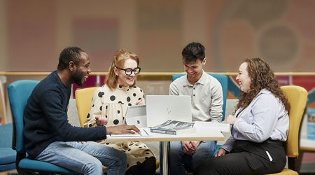 Happy colleagues chatting and working around a desk