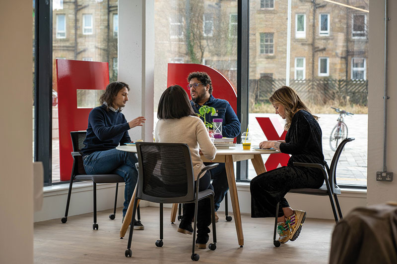 Photo of four people using the Bright Red Triangle space at Napier University