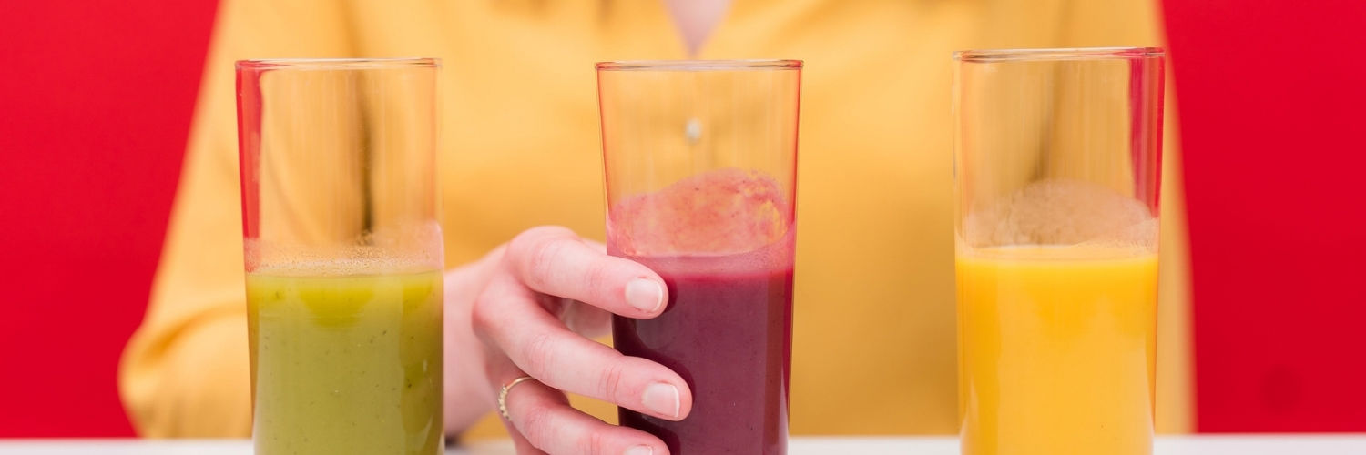 A QMU student sampling various drinks at a food testing.