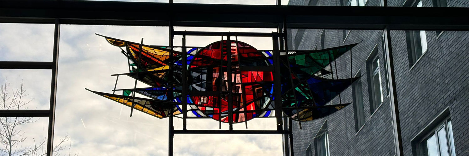 A coloured glass window art piece featured up high on QMU campus.