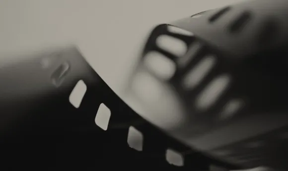 A blurred black photo of a old fashioned film reel.
