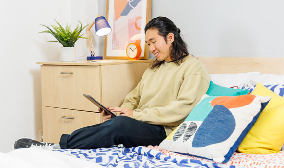 A student using a tablet device in their QMU Student Accommodation