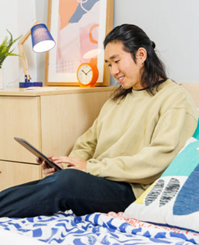 A student using a tablet device in their QMU Student Accommodation