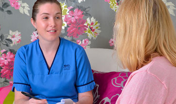 QMU student nurse talking to a patient and taking notes