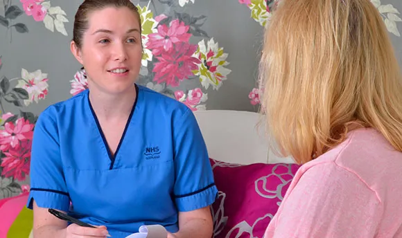 QMU student nurse talking to a patient and taking notes