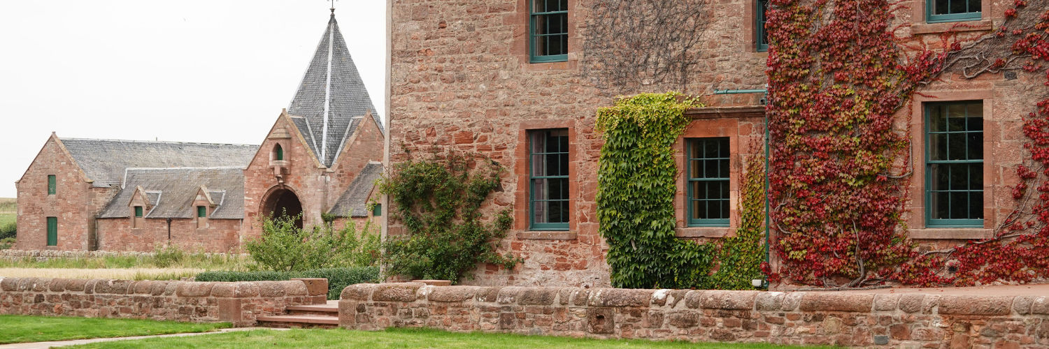 outside view of Papple Steading farm building made with old red stone sitting in attractive green countryside