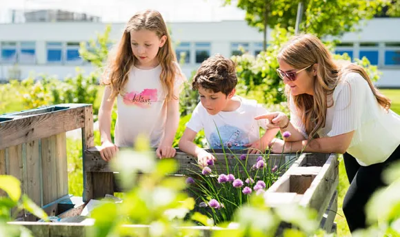 Teacher and young children in a community garden