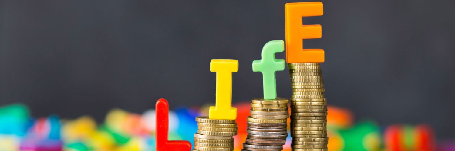 Stacks coins and letters spelling out 'life'